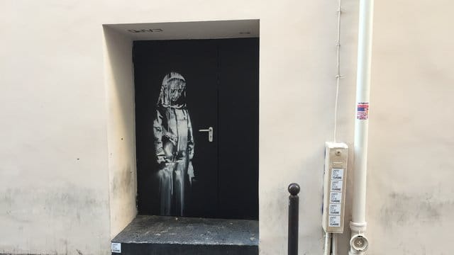 Auf einer Tür beim Pariser Musikclub "Bataclan" ist ein Wandbild zu sehen, das dem britischen Street-Art-Künstler Banksy zugerechnet wird. Auf einer Tür beim Pariser Musikclub "Bataclan" ist ein Wandbild zu sehen, das dem britischen Street-Art-Künstler Banksy zugerechnet wird.