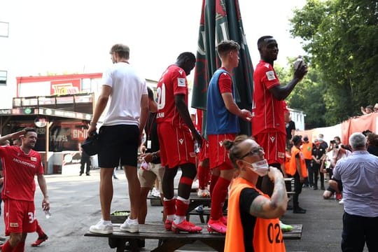 Spieler von Union Berlin feiern mit Fans auf der anderen Seite des Zauns am Stadion An der alten Försterei.