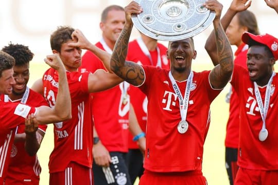 Thomas Müller feiert mit seinen Teamkameraden und Meisterschale.