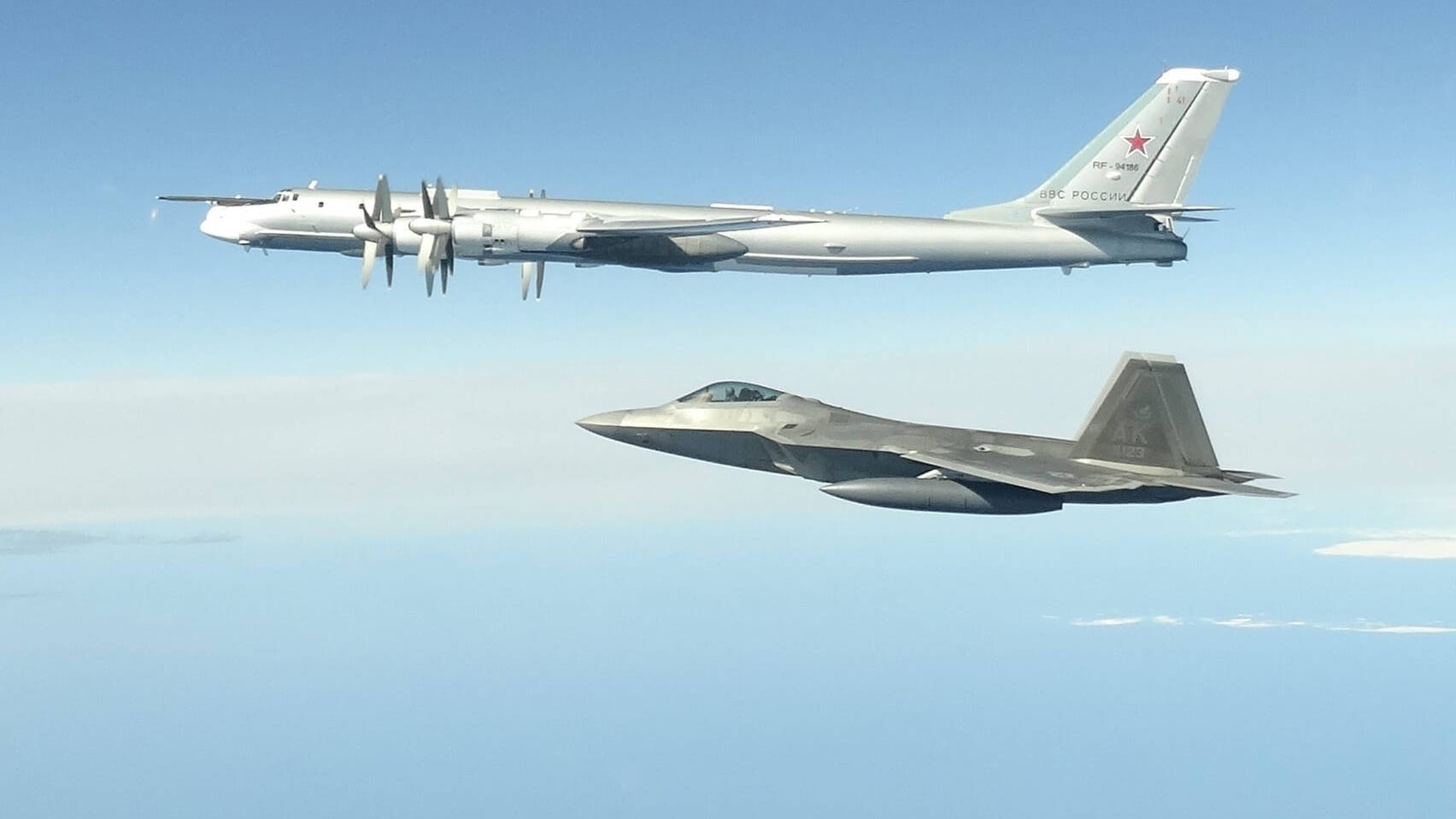 US-Kampfflugzeug vom Typ F-22 (unten) mit einer russischen TU-142: Vor Alaska haben US-Jets vier solcher russischen Aufklärer abgefangen. (Archivfoto)