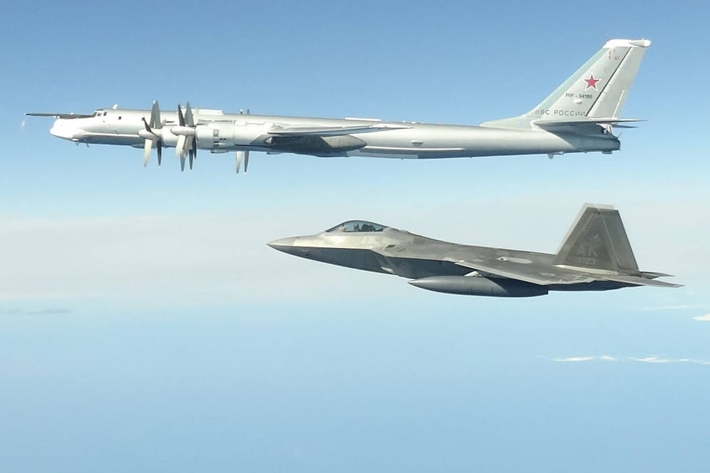 US-Kampfflugzeug vom Typ F-22 (unten) mit einer russischen TU-142: Vor Alaska haben US-Jets vier solcher russischen Aufklärer abgefangen. (Archivfoto)