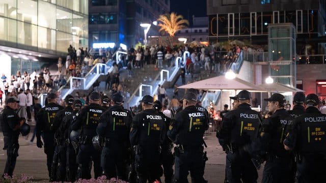 Polizisten stehen auf dem Schlossplatz vor einer Treppe