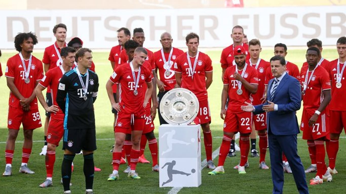 Christian Seifert überreicht nach einer denkwürdigen Saison den Bayern-Profis die Meisterschale.