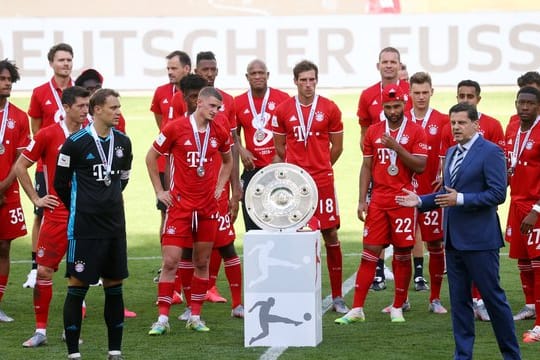 Christian Seifert überreicht nach einer denkwürdigen Saison den Bayern-Profis die Meisterschale.