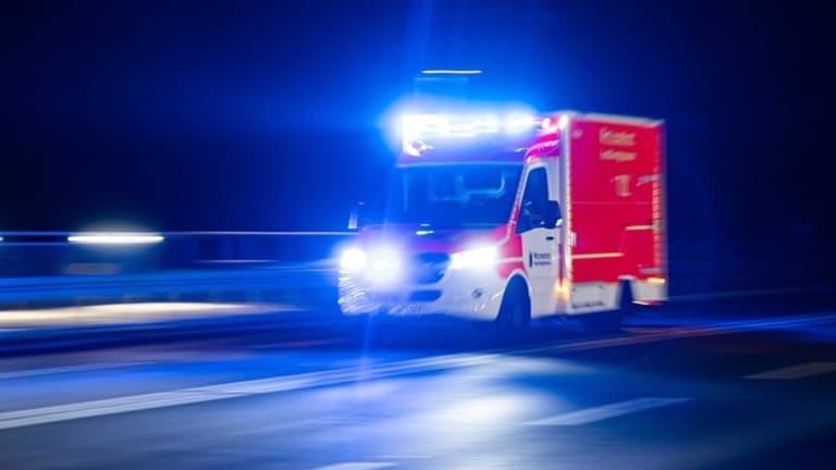 Ein Rettungswagen der Feuerwehr fährt mit Blaulicht durch eine Straße (Symbolbild): In Köln ist es zu einem Unfall mit einem Laster und zwei Fahrradfahrern gekommen.
