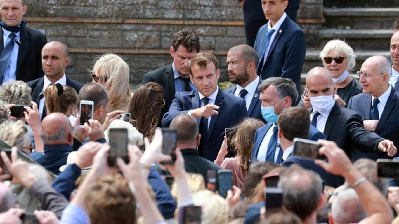 Emmanuel Macron (hinten,M) nach der Stimmabgabe im nordfranzösischen Seebad Le Touquet.
