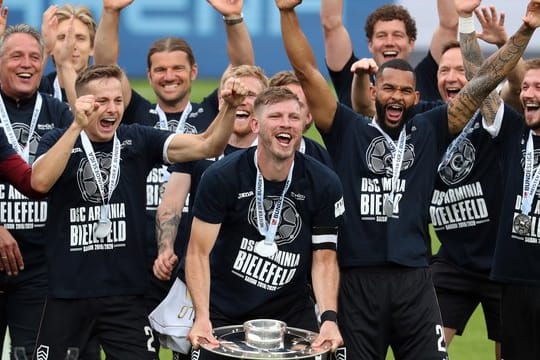 Bielefelds Fabian Klos (M) feiert mit der Meisterschale in Händen mit seinen Teamkameraden.