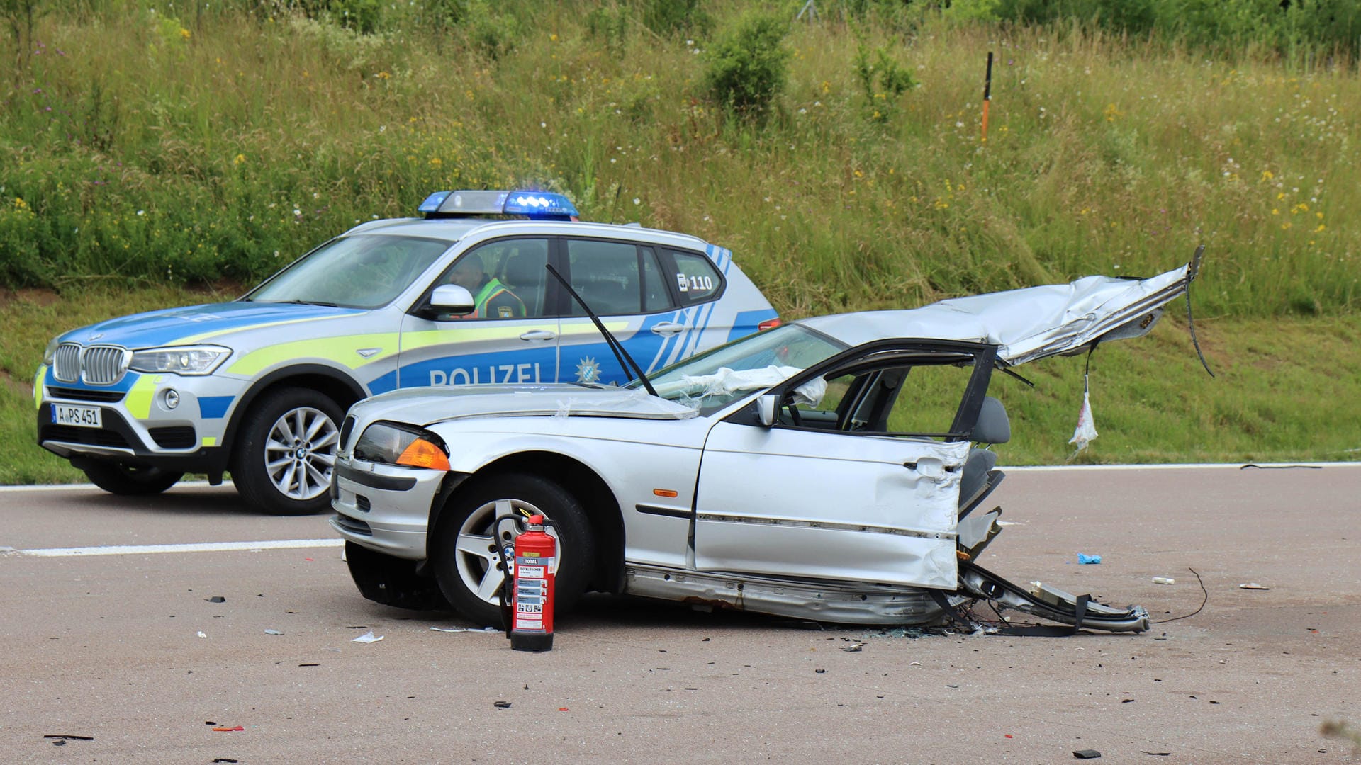 Ein in der Mitte zerrissenes Auto steht auf der Autobahn 8. Bei dem schweren Verkehrsunfall sind am Montag eine Frau getötet und vier Menschen verletzt worden.