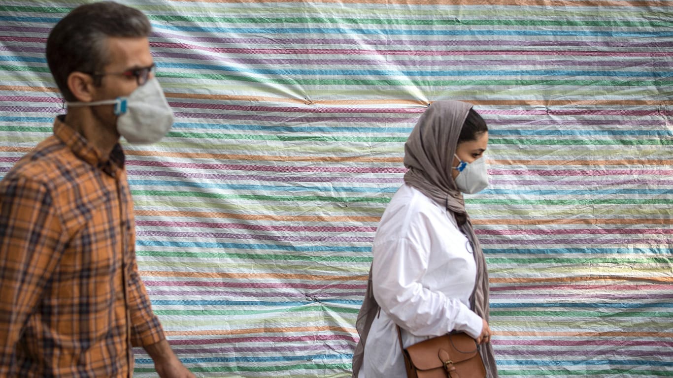 Menschen mit Masken in den Straßen Teherans: Im Iran steigen die Fallzahlen.