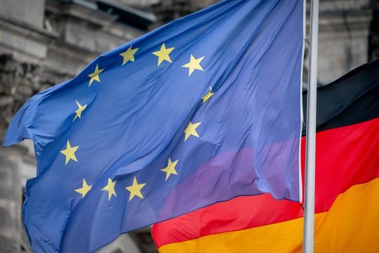Die Deutschland- und die Europaflagge vor dem Reichstagsgebäude.
