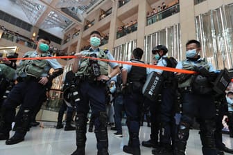 Polizisten in einem Einkaufszentrum in Hongkong: Erste Festnahme unter dem neuen Gesetz, das Demokratie-Aktivisten kleinhalten soll.