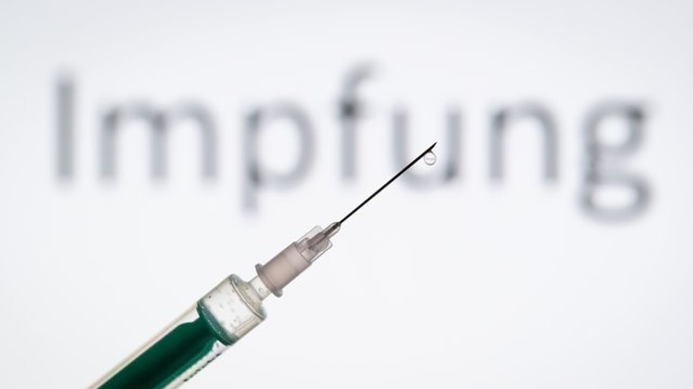 Eine Spritze wird vor einen Schriftzug "Impfung" gehalten (Symbolbild): Das Mainzer Unternehmen Biontech testet in Deutschland und den USA neue Impfstoffe gegen das Coronavirus.