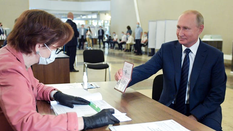 Wladimir Putin zeigt einer Mitarbeiterin der Wahlkommission seinen Pass in einem Wahllokal: Zuvor hatte der russische Präsident einen Wahlkampf für seine Verfassungsänderungen geführt.