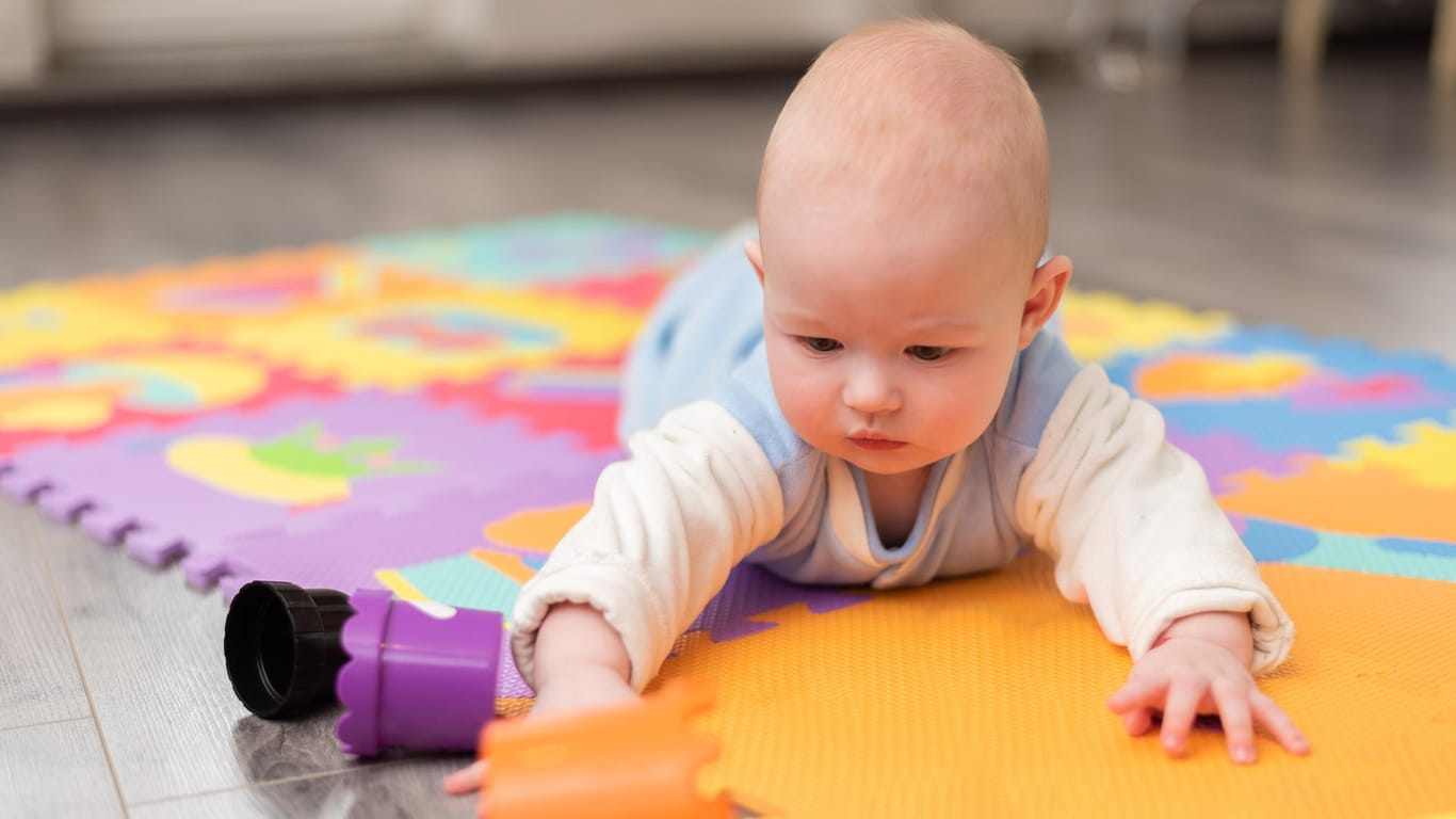 Baby in Bauchlage: Im Alter von vier bis sieben Monaten drehen sich Säuglinge meist schon selbst vom Rücken auf den Bauch.