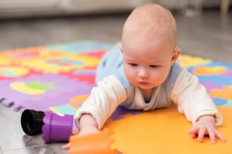 Baby in Bauchlage: Im Alter von vier bis sieben Monaten drehen sich Säuglinge meist schon selbst vom Rücken auf den Bauch.