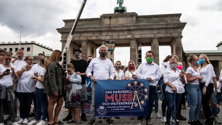 Teilnehmer an der Kundgebung des deutschen Schaustellerbundes stehen mit Plakaten am Brandenburger Tor: Sie protestierten gegen das Verbot von Großveranstaltungen bis mindestens Ende Oktober.