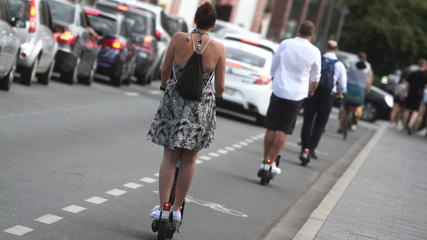 Eine Frau fährt mit einem E-Roller: In Nürnberg soll ein Mann eine E-Scooter-Fahrerin am Gesäß berührt haben – daraufhin stieß sie mit anderen Rollerfahrerinnen zusammen.