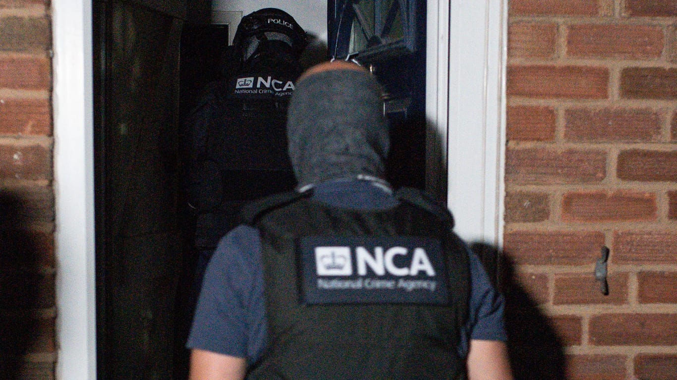 Razzia in Birmingham: Beamte der National Crime Agency, vergleichbar mit dem Bundeskriminalamt, durchsuchen ein Gebäude.