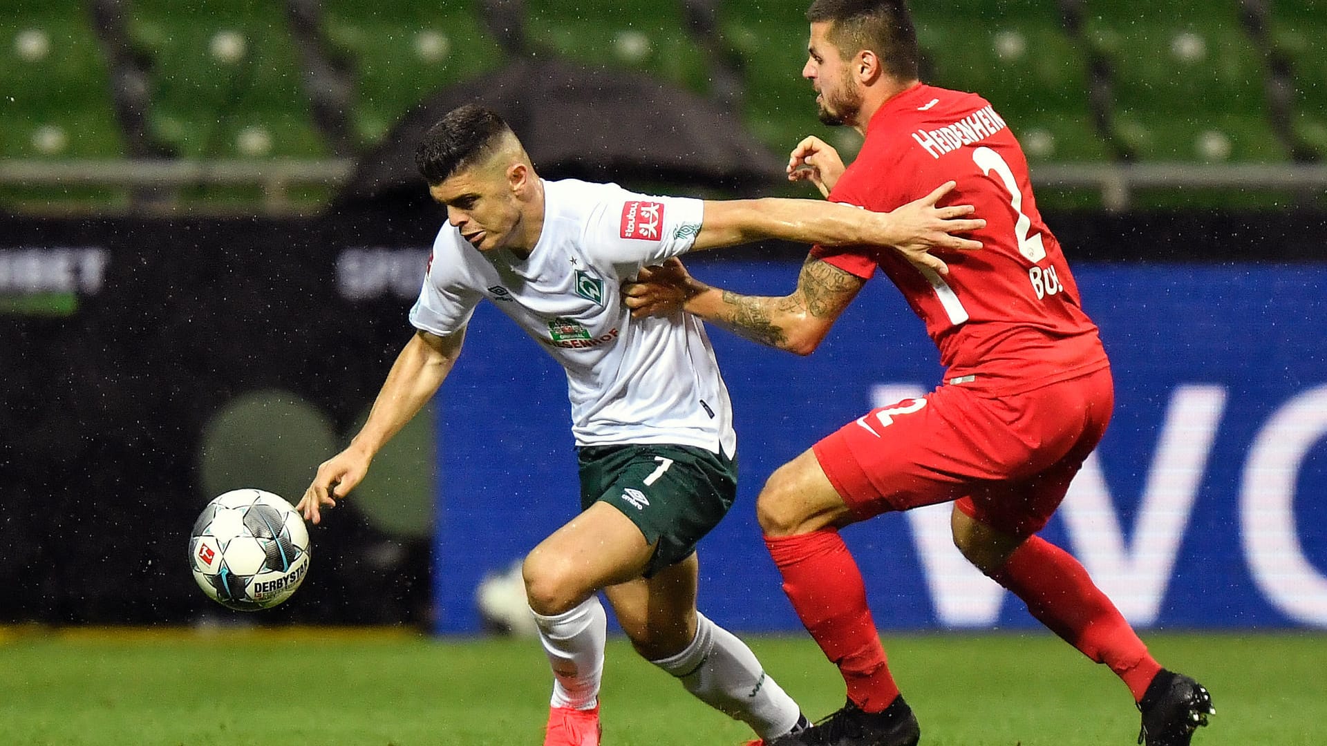 Bei Regenwetter im Weser-Stadion: Bremens Milot Rashica (li) und Heidenheims Marnon Busch kämpfen um den Ball.