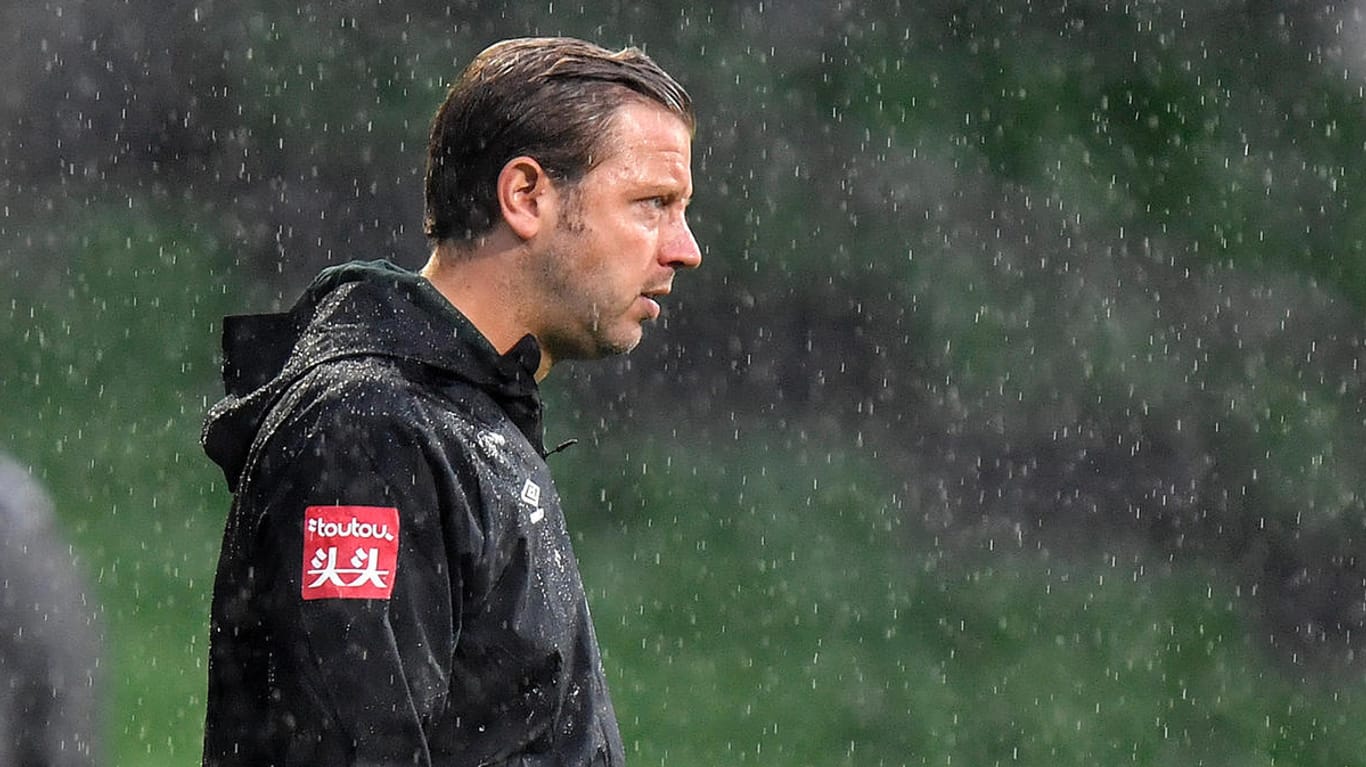 Bremen-Trainer Florian Kohfeldt steht im Regen.