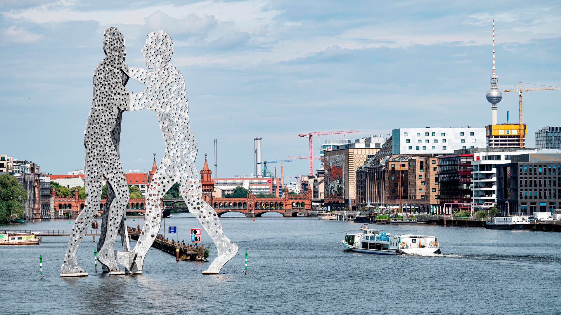 Ein Ausflugsschiff fährt am "Molecule Man" in der Spree vorbei: Das Wochenende wird in Berlin und Brandenburg sommerlich warm.