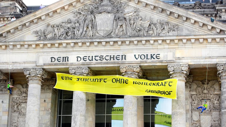 Greenpeace-Aktivisten bringen ein Banner am Reichstagsgebäude an: Den Umweltschützern geht das Gesetz zum Kohleausstieg bis 2038 nicht weit genug.