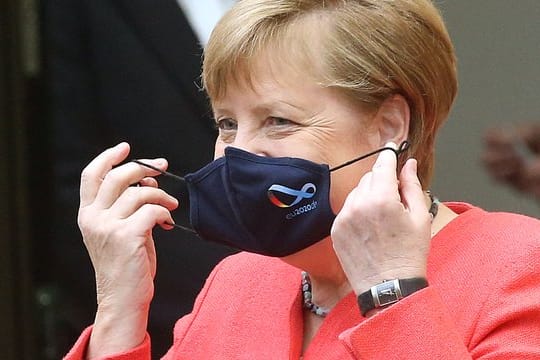 Bundeskanzlerin Angela Merkel (CDU) nimmt im Bundesrat ihre Mund- und Nasenschutzmaske ab, bevor sie eine Rede zu Zielen der EU-Ratspräsidentschaft hält.