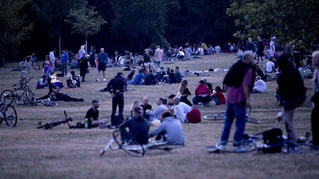 Menschen sitzen nachts im Volkspark Hasenheide in Berlin auf einer Wiese: Dort treffen sich besonders am Wochenende viele Menschen, teilweise um zu Feiern. Menschen sitzen nachts im Volkspark Hasenheide in Berlin auf einer Wiese: Dort treffen sich besonders am Wochenende viele Menschen, teilweise um zu Feiern.