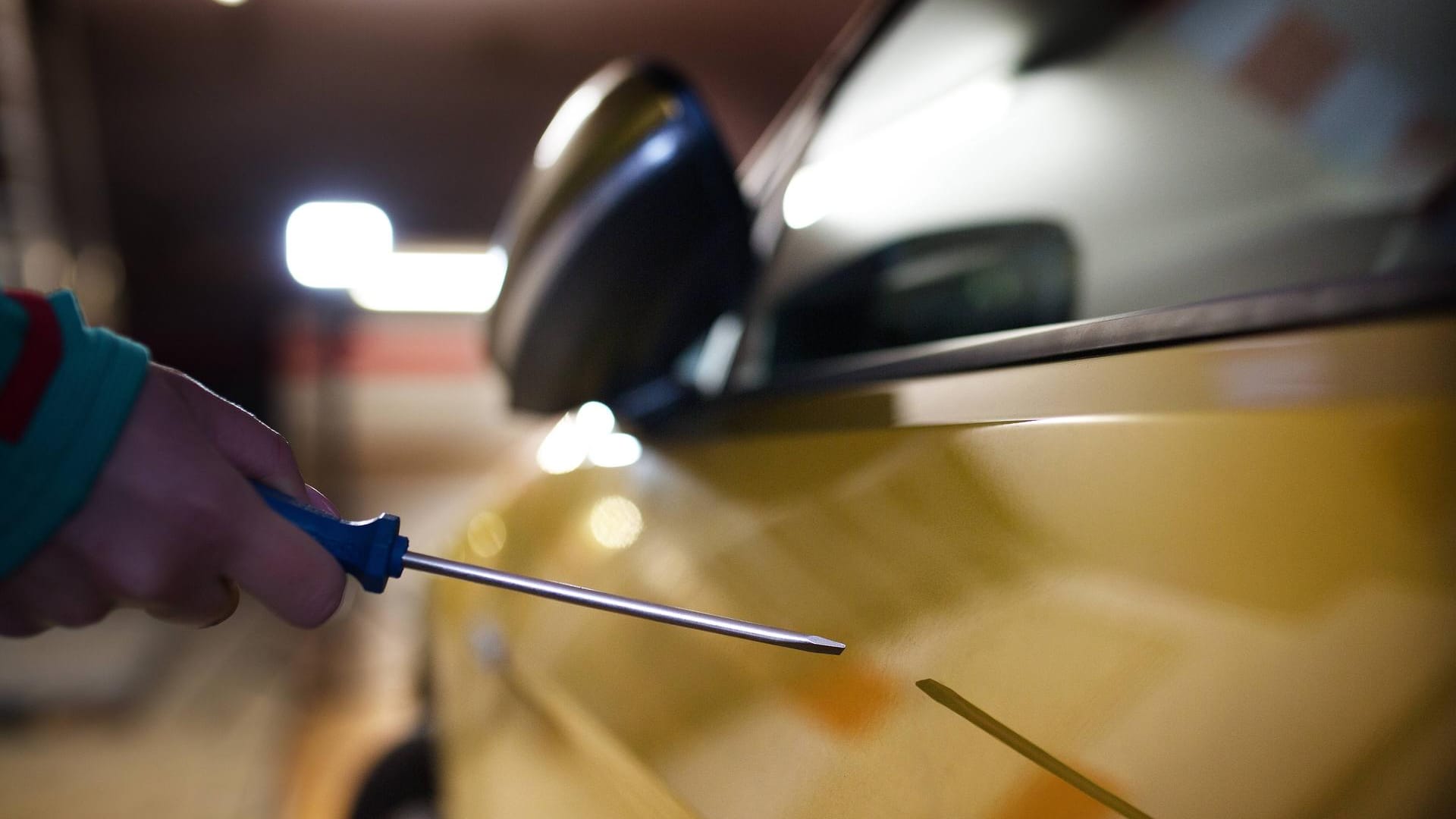 Eine Hand zerkratzt mit einem Schraubenzieher ein Auto (Symbolbild): In Stuttgart wurden Dutzende Autos beschädigt.