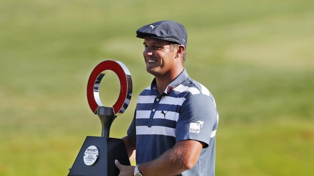 Bryson DeChambeau hält die Trophäe des Golfturniers Rocket Mortgage Classic in den Händen. Bryson DeChambeau hält die Trophäe des Golfturniers Rocket Mortgage Classic in den Händen.