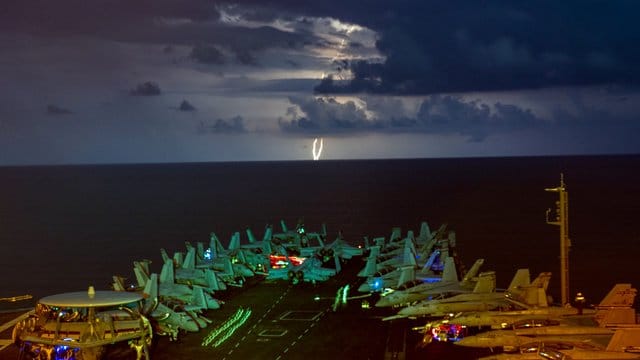 Militärjets stehen auf dem Flugdeck des Flugzeugträgers USS Nimitz (CVN 68) im Südchinesischen Meer während eines Gewitters. Militärjets stehen auf dem Flugdeck des Flugzeugträgers USS Nimitz (CVN 68) im Südchinesischen Meer während eines Gewitters.