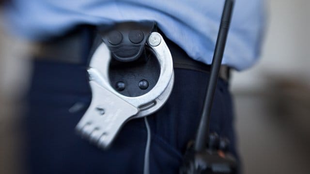 Handschellen hängen am Gürtel eines Justizbeamten Handschellen hängen am Gürtel eines Justizbeamten