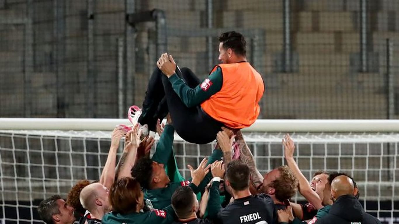 Claudio Pizarro von Werder Bremen wird nach Spielende von seinen Teamkollegen in die Luft geworfen.
