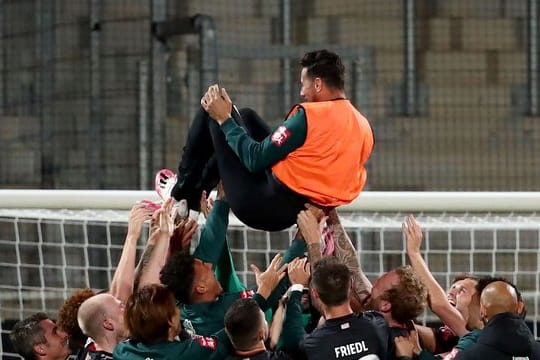 Claudio Pizarro von Werder Bremen wird nach Spielende von seinen Teamkollegen in die Luft geworfen.