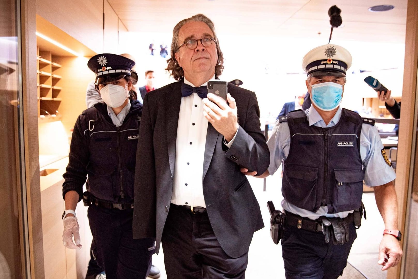 Polizeibeamte begleiten den parteilosen Abgeordneten Heinrich Fiechtner aus dem Saal des Landtags Baden-Württemberg im April: Er wurde bereits mehrmals von Sitzungen ausgeschlossen.