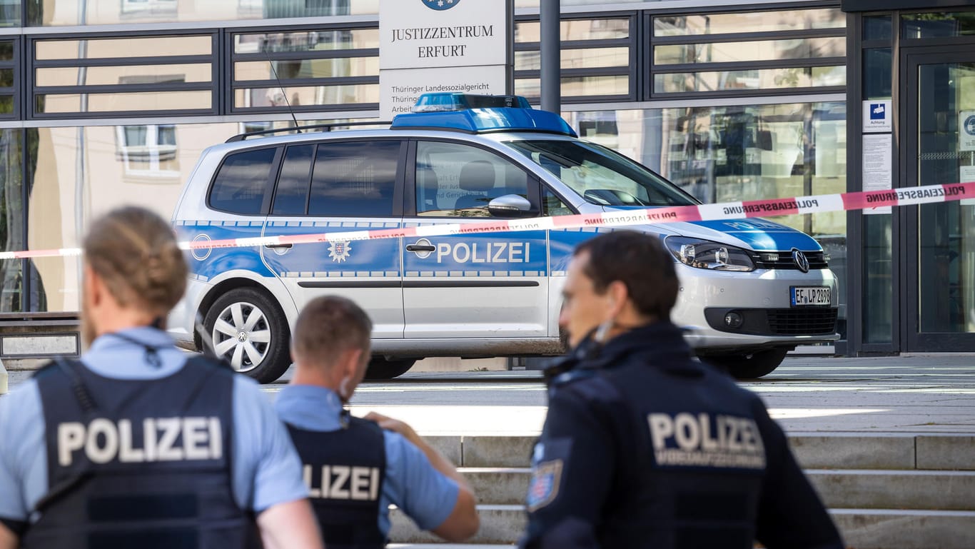 Polizisten stehen nach einer Bombendrohung vor dem Thüringer Justizzentrum in Erfurt: In zahlreichen deutschen Städten gingen am Dienstagmorgen Bombendrohungen gegen Gerichte ein, etliche Gebäude wurden geräumt.