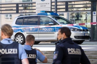 Polizisten stehen nach einer Bombendrohung vor dem Thüringer Justizzentrum in Erfurt: In zahlreichen deutschen Städten gingen am Dienstagmorgen Bombendrohungen gegen Gerichte ein, etliche Gebäude wurden geräumt.