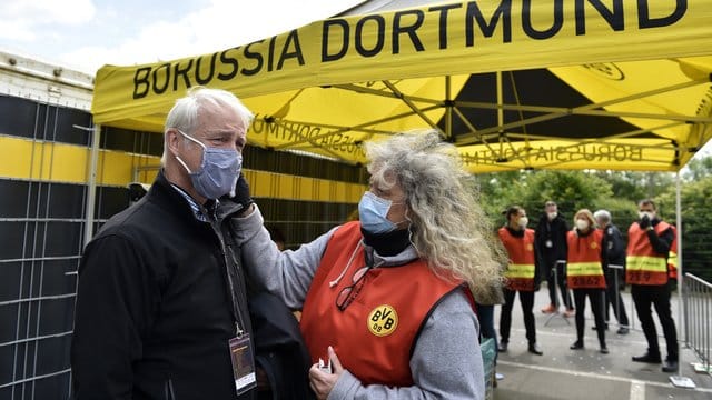 Beim Mitglied einer TV-Crew wird vor dem Einlass ins Stadion die Temperatur gemessen. Beim Mitglied einer TV-Crew wird vor dem Einlass ins Stadion die Temperatur gemessen.