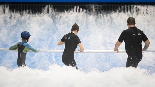 Anfänger surfen im Berliner Wellenwerk zunächst mit Haltestange.