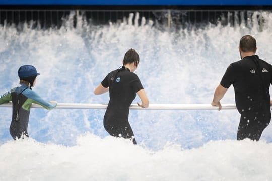 Anfänger surfen im Berliner Wellenwerk zunächst mit Haltestange.