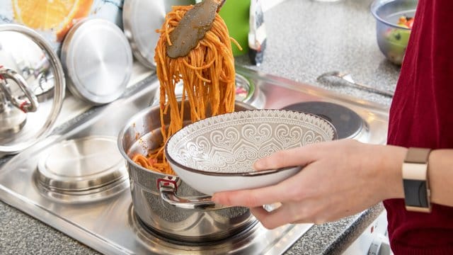 Essen servieren: Zum Warmhalten des Gerichts können Sie den Topf auf der Herdplatte stehen lassen.