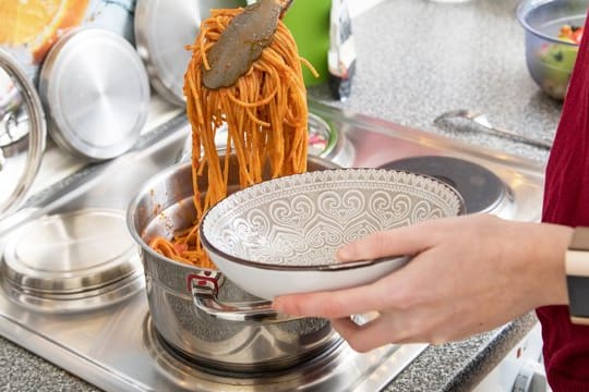 Essen servieren: Zum Warmhalten des Gerichts können Sie den Topf auf der Herdplatte stehen lassen.