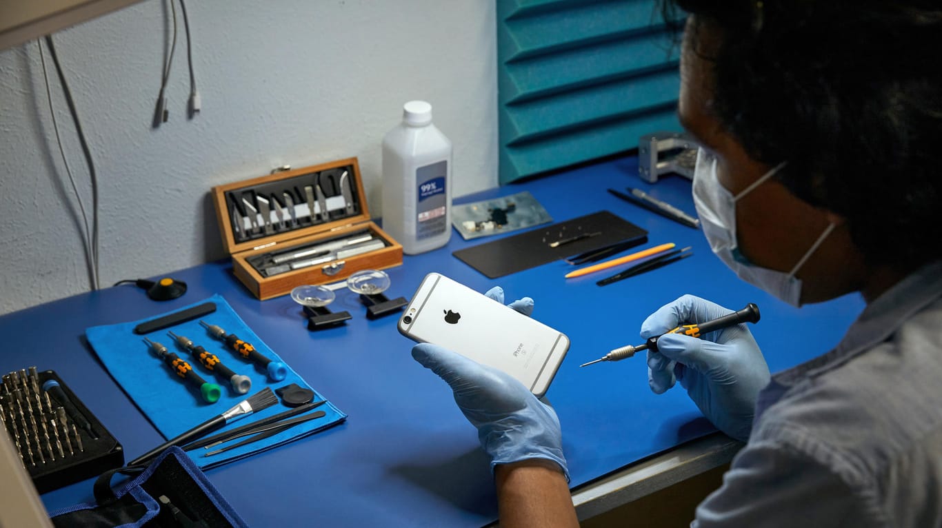 Ein Service-Techniker arbeitet an einem Apple iPhone: Apple beliefert freie Werkstätten in Europa mit Original-Ersatzteilen.