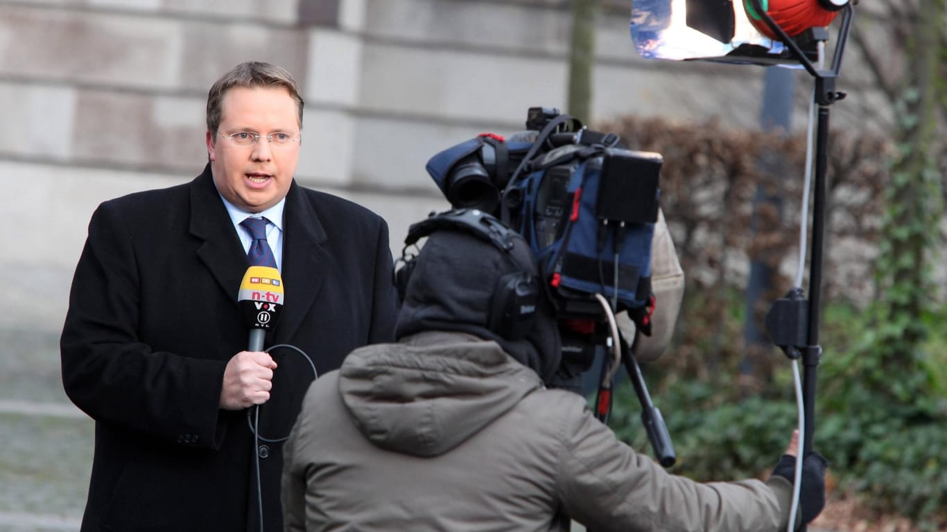 Symbolbild: Ein TV-Reporter und ein Kameramann während einer Live-Schalte von RTL.