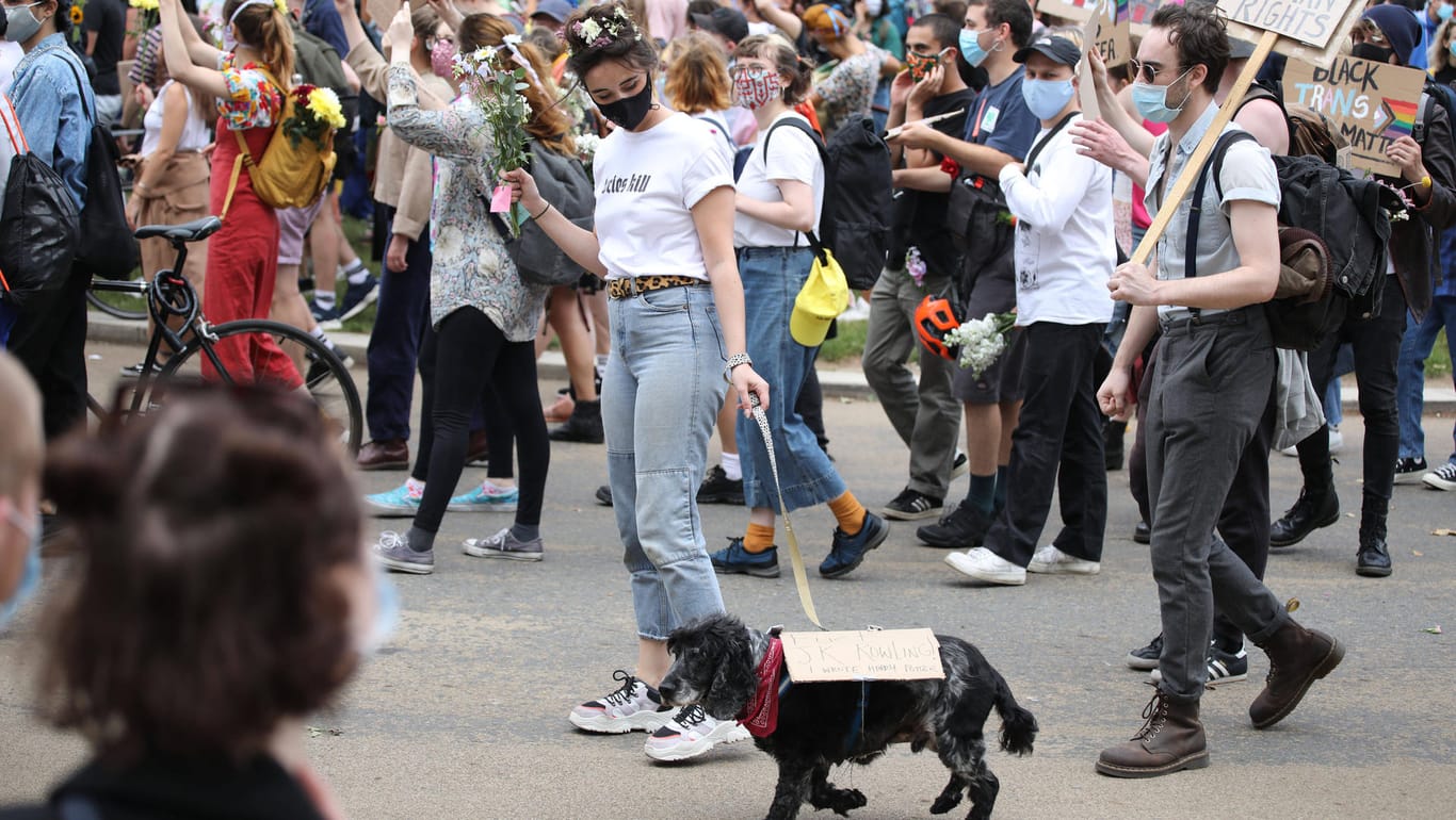 "Black Lives Matter"-Proteste in London: Eine Demonstrantin führt einen Hund spazieren, der ein Schild mit der Aufschrift "Fuck J.K. Rowling" trägt.