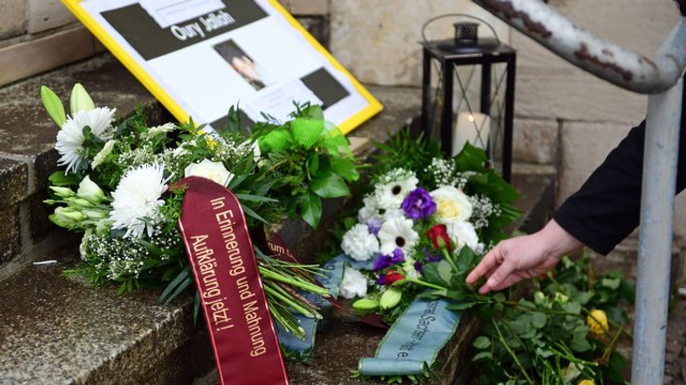 Teilnehmer einer Mahnwache haben zum Gedenken an Oury Jalloh Blumen und Kerzen an einer Treppe vor dem Polizeirevier in Dessau-Roßlau niedergelegt.