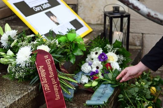Teilnehmer einer Mahnwache haben zum Gedenken an Oury Jalloh Blumen und Kerzen an einer Treppe vor dem Polizeirevier in Dessau-Roßlau niedergelegt.