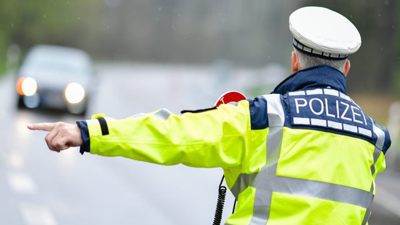 Ein Polizist bei einer Geschwindigkeitskontrolle an einer Bundesstraße.