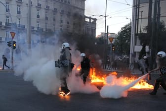 Proteste in Griechenland: Bereitschaftspolizisten versuchen vor dem griechischen Parlament Flammen auszuweichen, während einer Demonstration gegen das neue Protestgesetz.