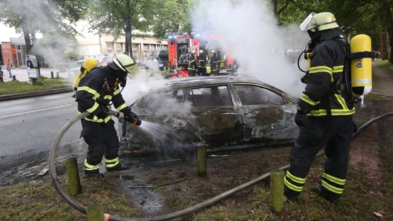 Feuerwehrleute löschen während des G20-Gipfels im Jahr 2017 ein brennendes Auto in Hamburg-Altona.